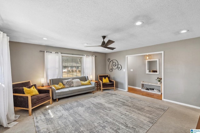 living area featuring a textured ceiling, recessed lighting, carpet flooring, a ceiling fan, and baseboards