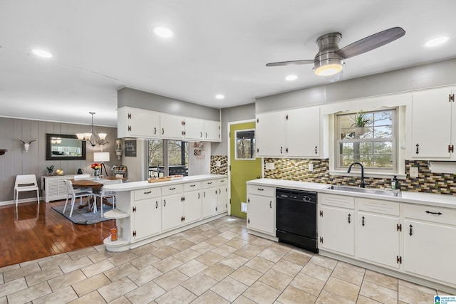 kitchen featuring a sink, white cabinets, light countertops, decorative backsplash, and dishwasher