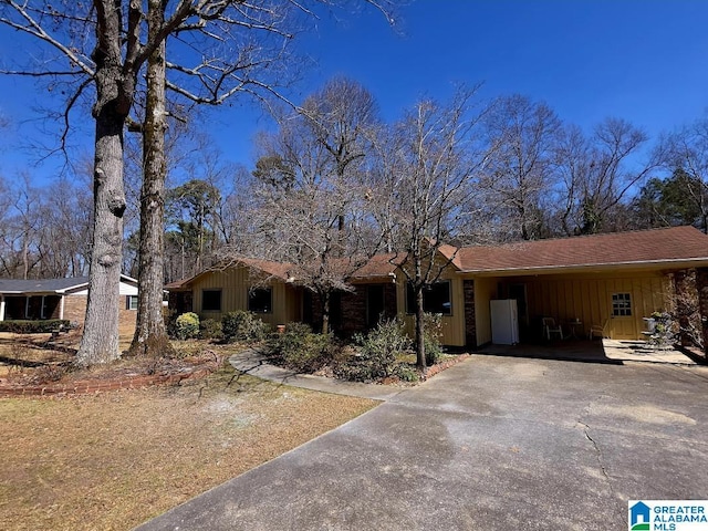 single story home with driveway and board and batten siding