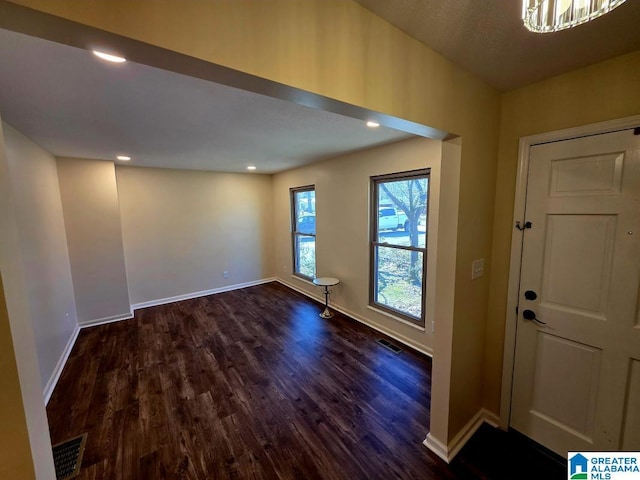 foyer featuring baseboards, visible vents, dark wood-type flooring, and recessed lighting