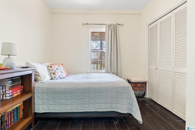 bedroom with dark wood-style floors and a closet