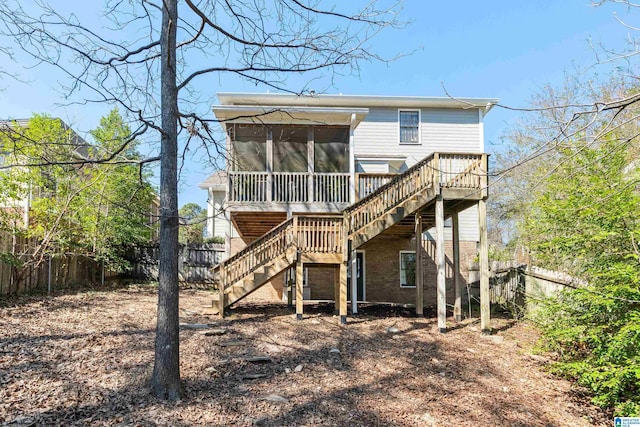 back of property featuring a sunroom, a fenced backyard, brick siding, and stairway