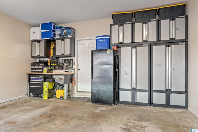 garage with a workshop area and freestanding refrigerator