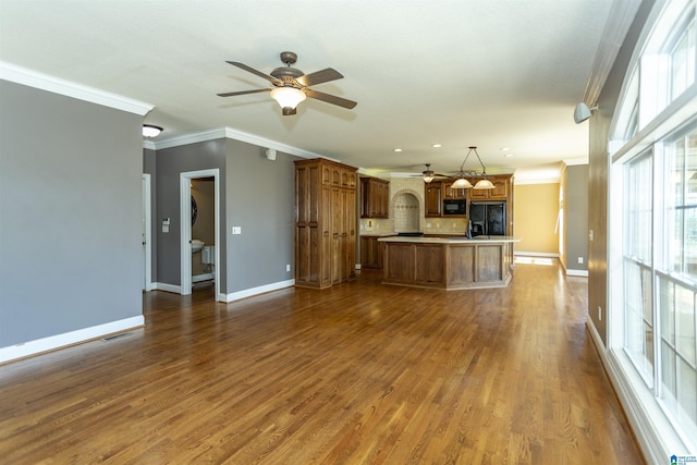 unfurnished living room with visible vents, dark wood-style floors, and crown molding