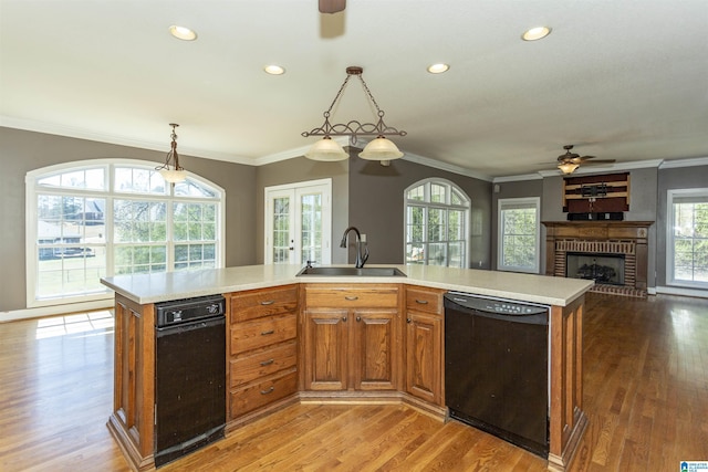 kitchen with open floor plan, light countertops, black dishwasher, and a sink