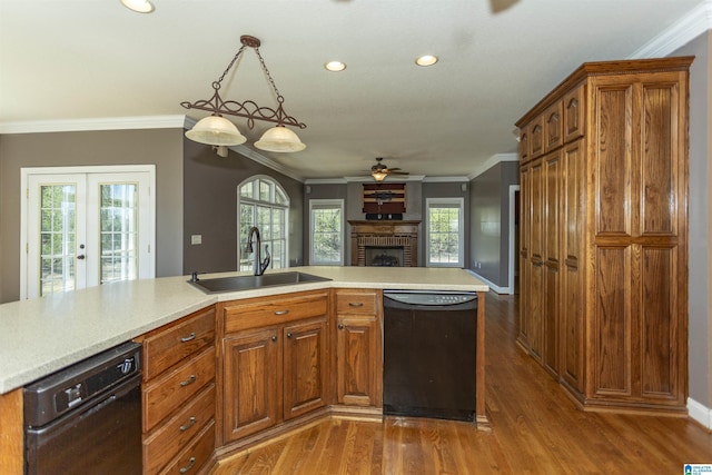 kitchen with light countertops, black dishwasher, crown molding, and a sink