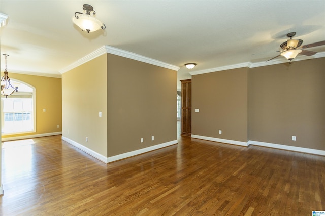 spare room featuring baseboards, wood finished floors, crown molding, and ceiling fan with notable chandelier