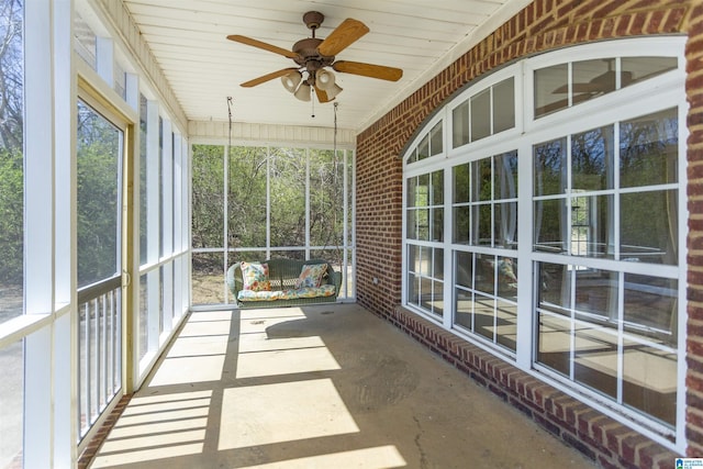 unfurnished sunroom featuring a ceiling fan