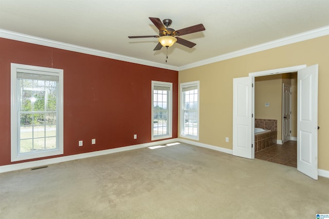 unfurnished bedroom featuring visible vents, multiple windows, crown molding, and carpet