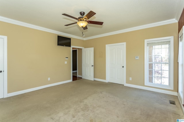 unfurnished bedroom with visible vents, ceiling fan, baseboards, carpet, and ornamental molding