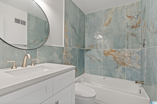 bathroom featuring tile walls, shower / bath combination, visible vents, toilet, and vanity