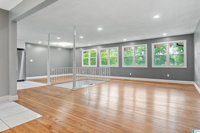 unfurnished room featuring light wood-type flooring, baseboards, and recessed lighting