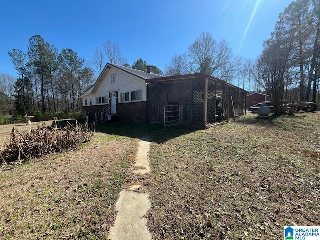 view of side of home featuring brick siding and a chimney