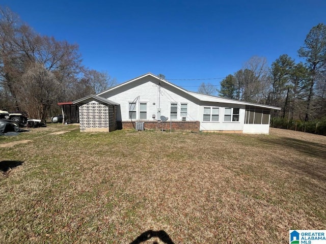 exterior space featuring a sunroom, a yard, and central AC unit