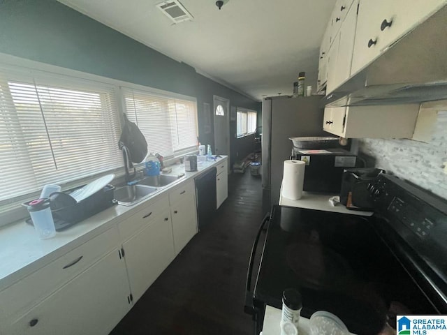 kitchen with light countertops, black electric range oven, a sink, under cabinet range hood, and dishwashing machine