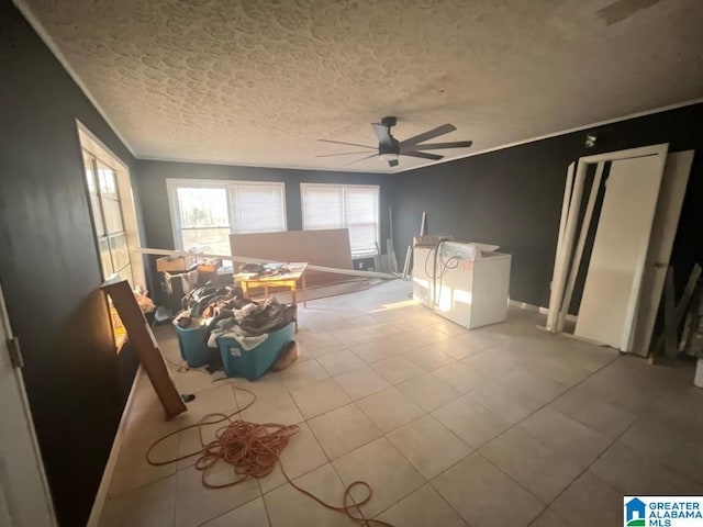 unfurnished living room featuring a ceiling fan, tile patterned flooring, crown molding, and a textured ceiling