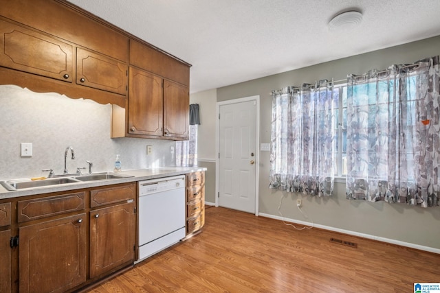 kitchen featuring a healthy amount of sunlight, visible vents, dishwasher, and a sink