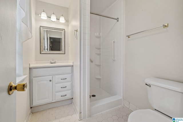 full bathroom featuring tile patterned flooring, toilet, vanity, baseboards, and tiled shower