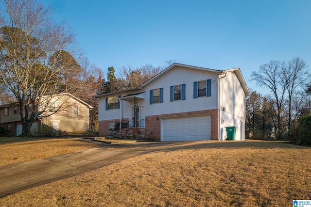 bi-level home with concrete driveway, brick siding, an attached garage, and a front yard