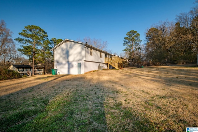 view of side of home with a yard, stairway, and a wooden deck