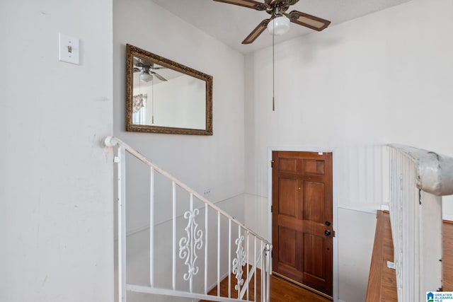 stairs with ceiling fan and wood finished floors