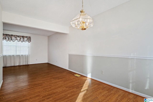 unfurnished room with baseboards, vaulted ceiling with beams, an inviting chandelier, and wood finished floors