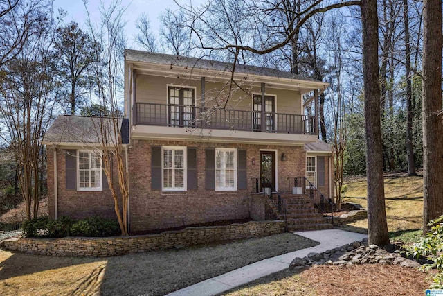 view of front facade featuring brick siding and a balcony