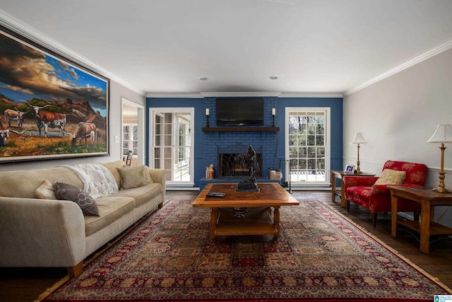 living room featuring a fireplace, crown molding, and wood finished floors