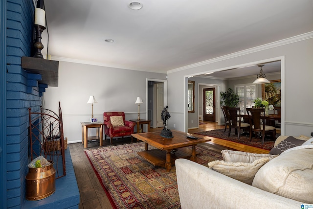 living area featuring baseboards, crown molding, and hardwood / wood-style floors