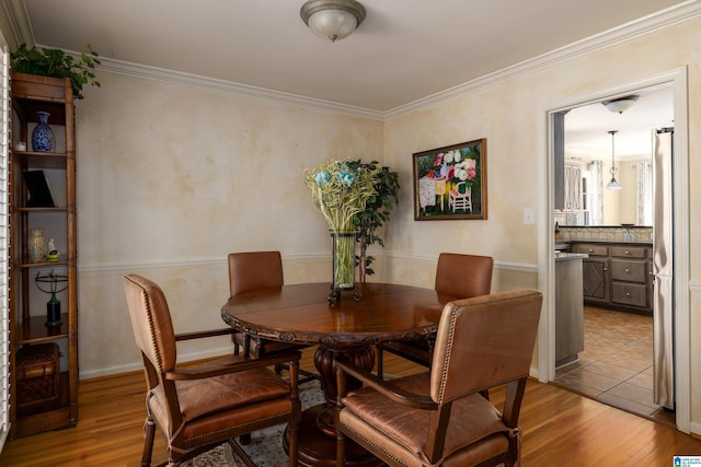 dining space featuring crown molding and wood finished floors