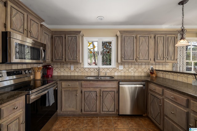 kitchen featuring crown molding, appliances with stainless steel finishes, a sink, and tasteful backsplash