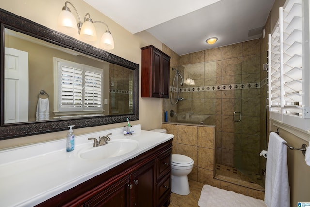 bathroom with toilet, a shower stall, tile patterned flooring, and vanity