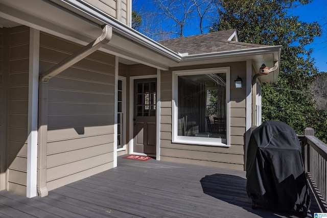 wooden deck with a garage and area for grilling