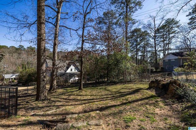 view of yard with fence and a forest view