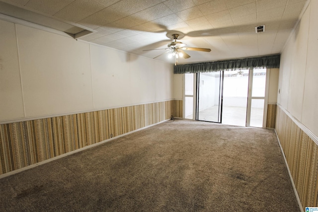 carpeted empty room with ceiling fan and visible vents