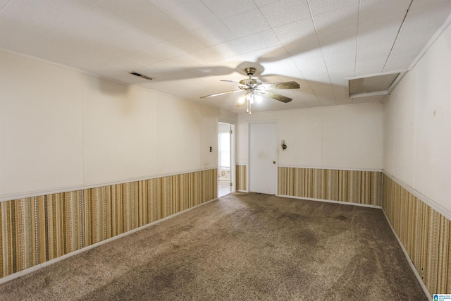 carpeted empty room with ceiling fan, visible vents, and wallpapered walls