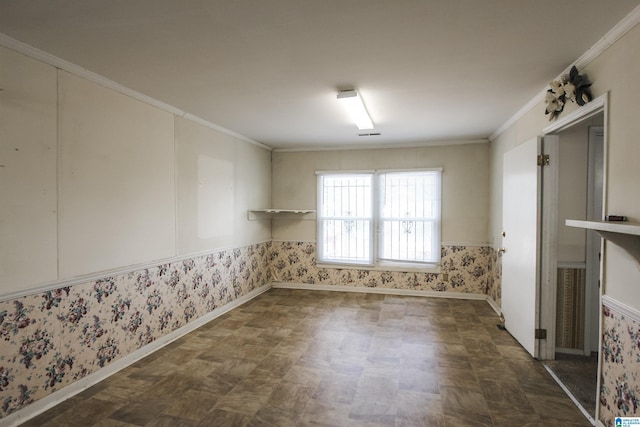 spare room with crown molding, baseboards, and wallpapered walls