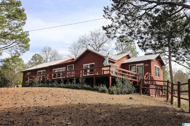 rear view of house featuring metal roof and a wooden deck