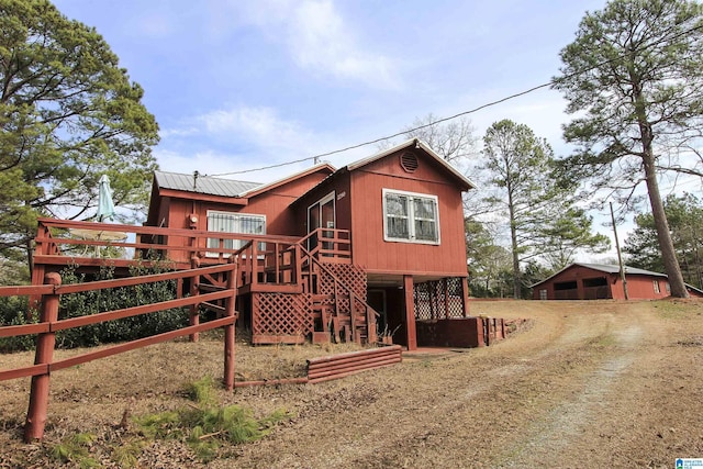 back of house with stairway and metal roof