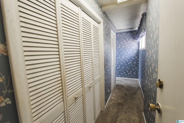 hallway with carpet, baseboards, and wallpapered walls