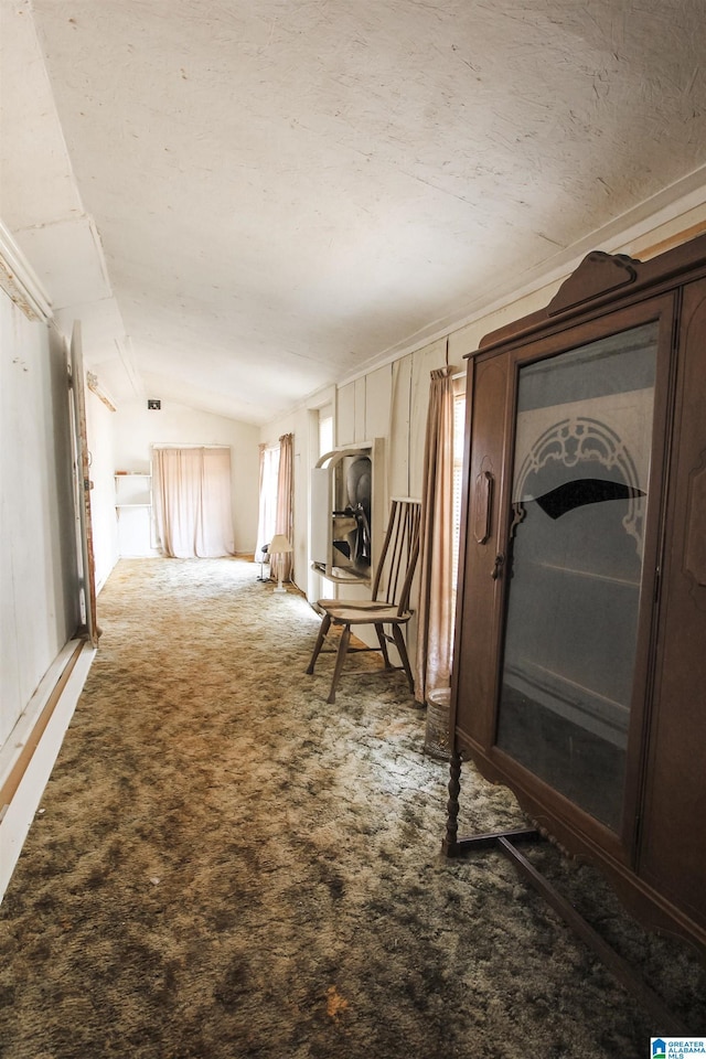 hall with lofted ceiling and carpet