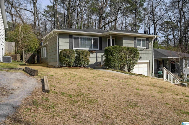 ranch-style house featuring a garage, a front yard, driveway, and central AC unit