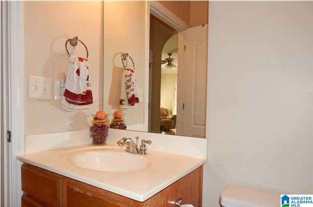 bathroom with toilet, ceiling fan, and vanity