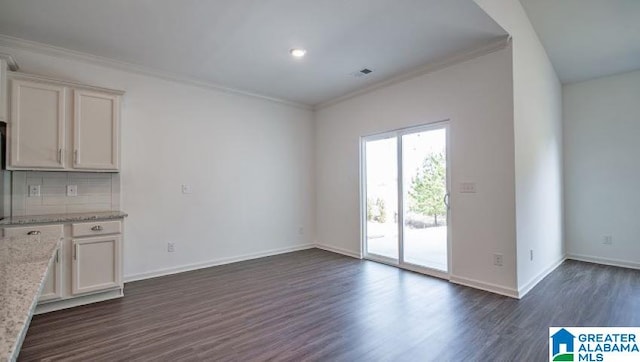 interior space featuring dark wood-style floors, baseboards, visible vents, and crown molding