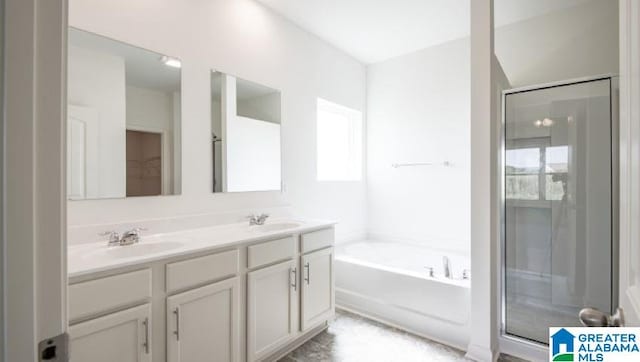 full bathroom featuring a sink, double vanity, a garden tub, and a shower stall