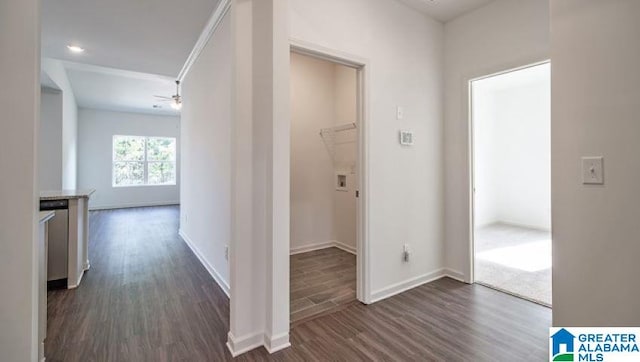 corridor with dark wood-style flooring and baseboards