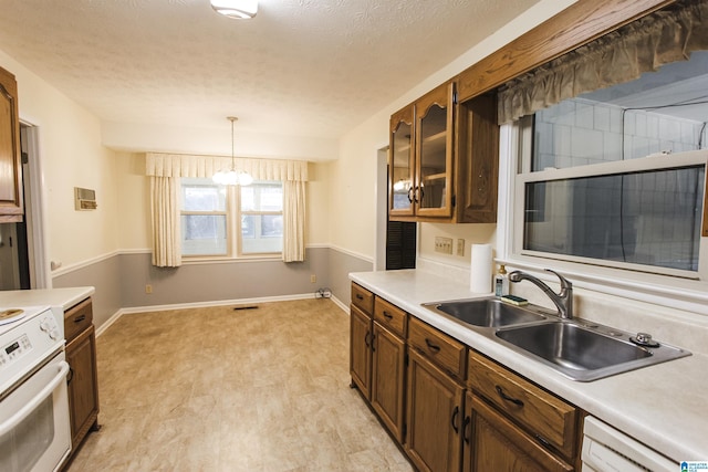 kitchen with a sink, electric stove, light countertops, dishwasher, and glass insert cabinets