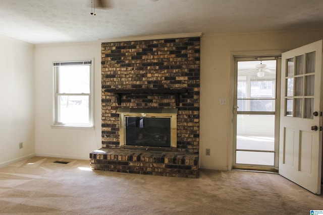 unfurnished living room featuring carpet floors, a brick fireplace, and a ceiling fan