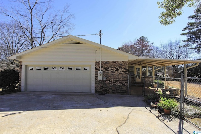 view of front of home featuring driveway, a garage, fence, and brick siding