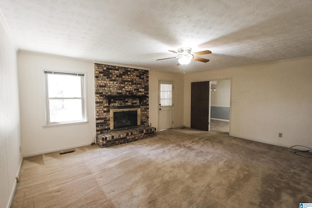 unfurnished living room featuring visible vents, a fireplace, a textured ceiling, and carpet flooring